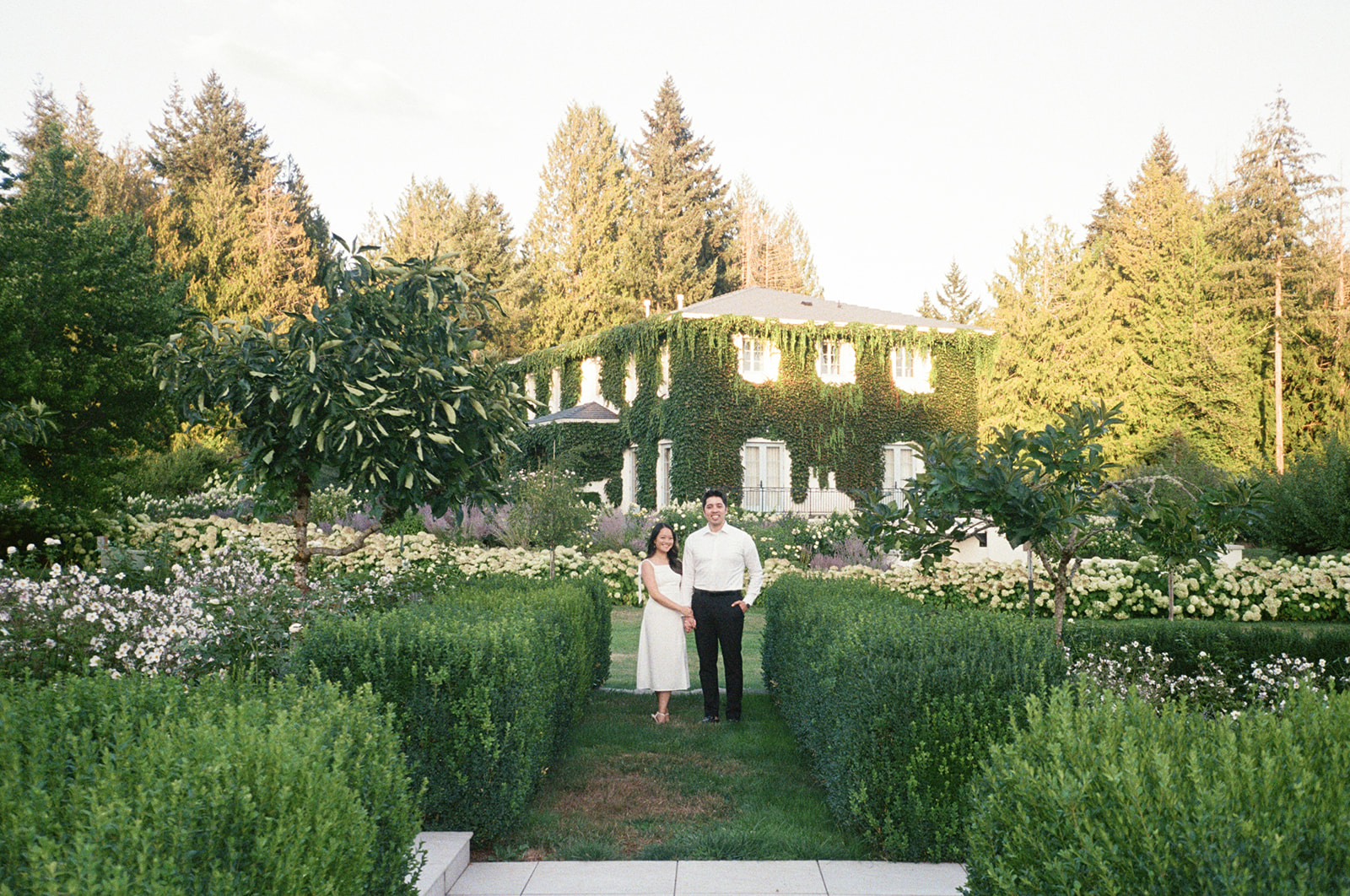 Couple walking through the gardens at Monet Vineyard during their engagement session