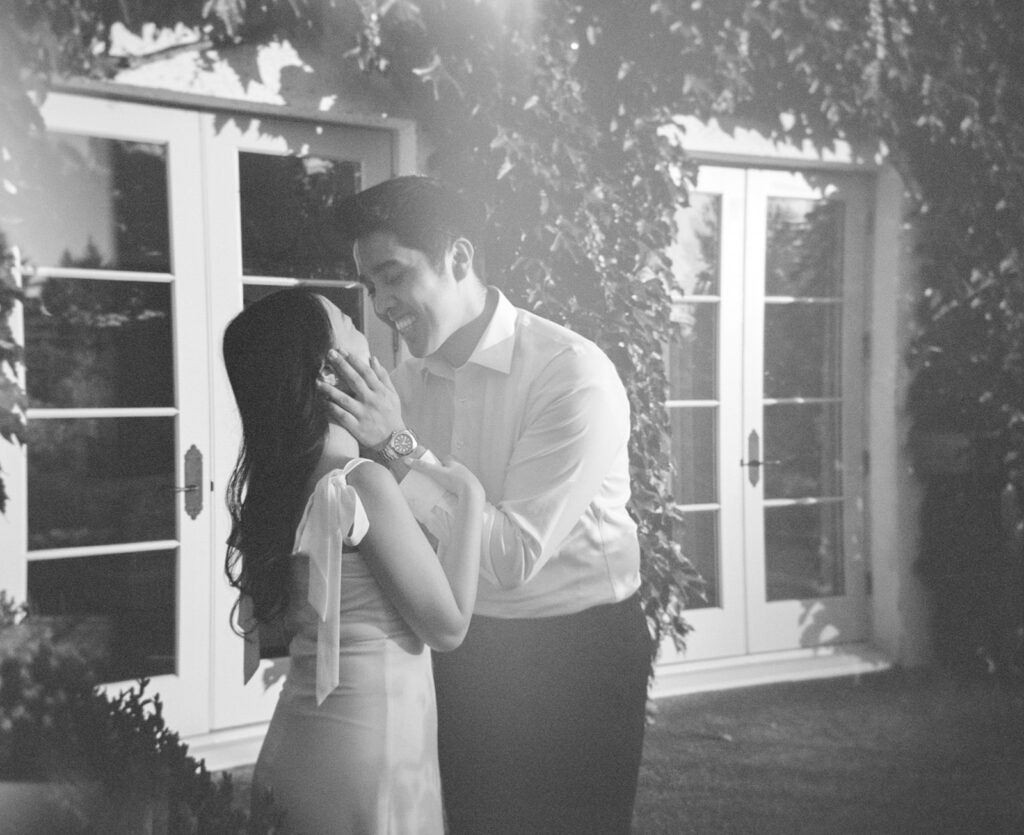 Romantic engagement photo surrounded by blooming hydrangeas at a vineyard estate
