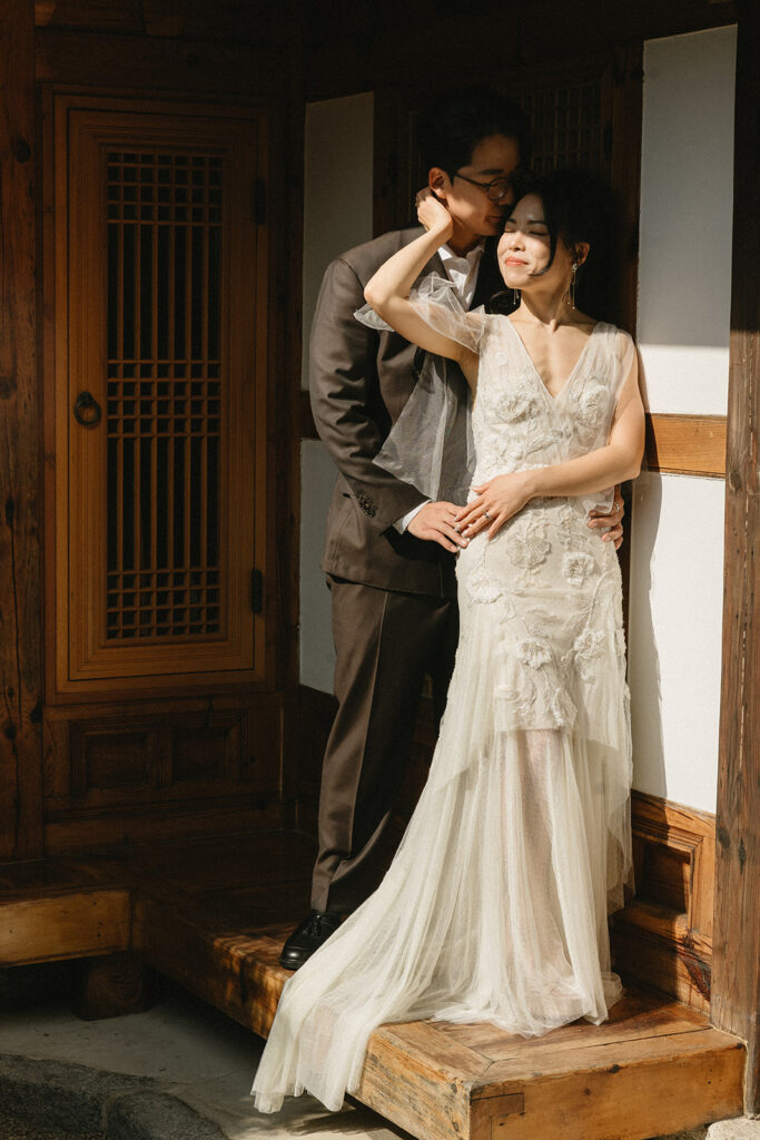 Bride and groom sharing a quiet moment during their wedding in Seoul surrounded by historic hanok architecture.
