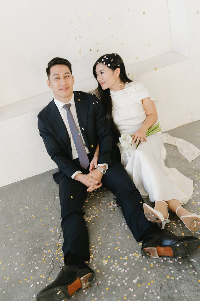 Bride and groom sharing a kiss in a bright white studio during a classic pre-wedding portrait session.
