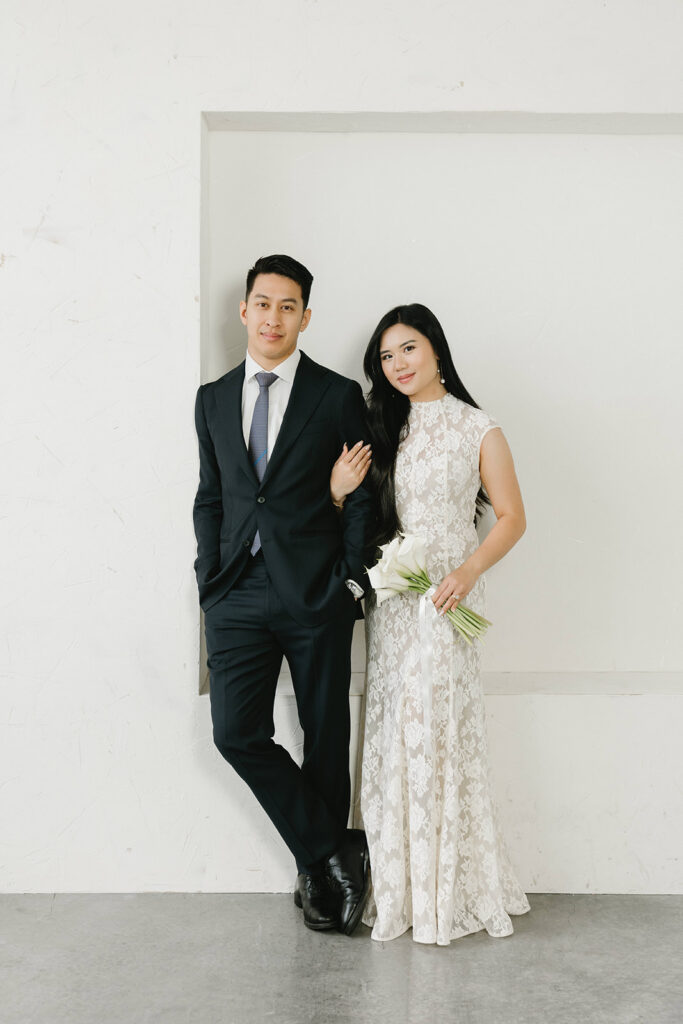 Bride and groom sharing a kiss during timeless and elegant pre-wedding portraits in studio in Portland at Cream Creative Space with soft natural light and minimal white backdrop.
