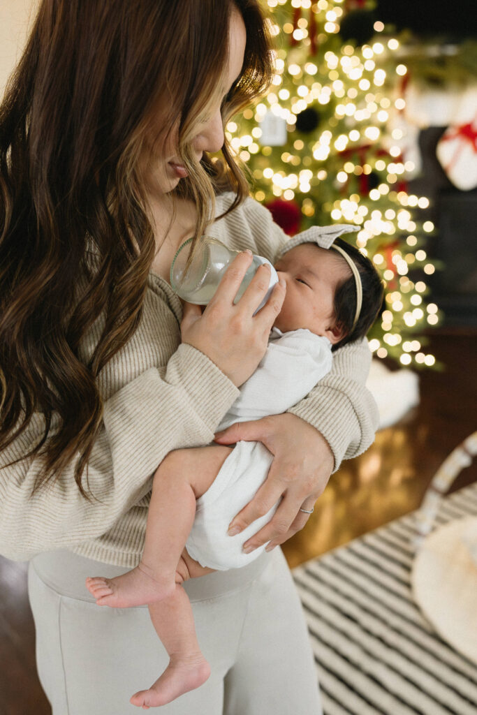 Parents together holding their newborn baby during a cozy in home newborn photoshoot
