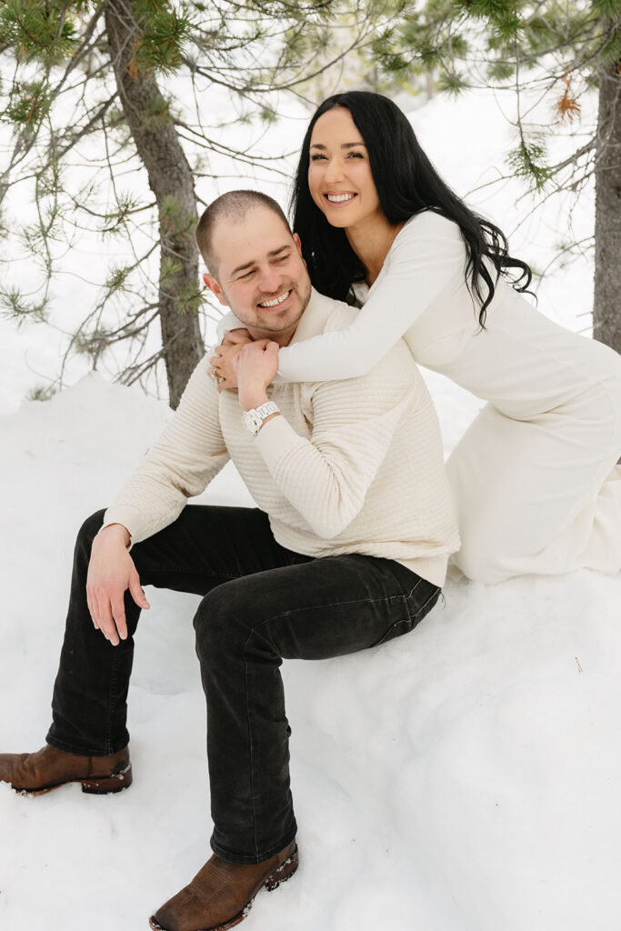 Romantic engagement photos in the snow with soft natural light and mountain views
